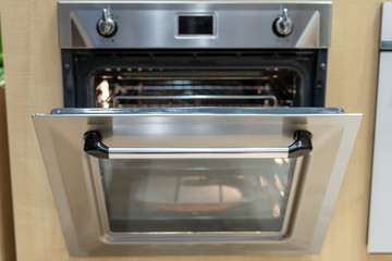 Open door on modern built-in oven in kitchen