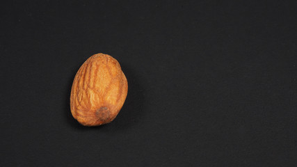 Raw almond isolated on black background.