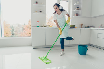 Full length body size side profile photo beautiful hardworking duties she her lady house dancing singing ear flaps on head wear jeans denim casual t-shirt covered cute apron bright light kitchen