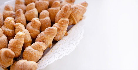 Basket with tasty croissants on white table
