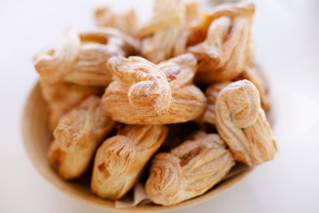 Basket with tasty croissants on white table