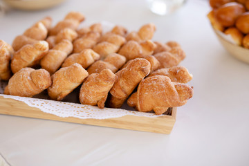 Basket with tasty croissants on white table