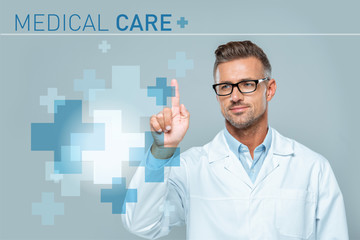 handsome scientist in white coat and glasses touching medical care interface in air isolated on grey, artificial intelligence concept