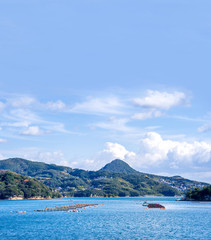Many small islands over the blue ocean in sunny day, famous Kujukushima(99 islands) pearl sea resort islet in Sasebo Saikai National Park, Nagasaki, Kyushu, Japan.