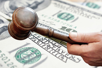 Finance concept,wooden judge gavel on us dollars background