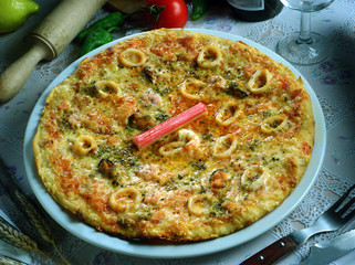 Una pizza marinera con, tomate, queso, calamares, cangrejo y mejillones.