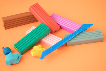 colored plasticine on on orange background