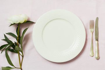Spring romantic dinner. Elegance table setting peony flowers on tablecloth.