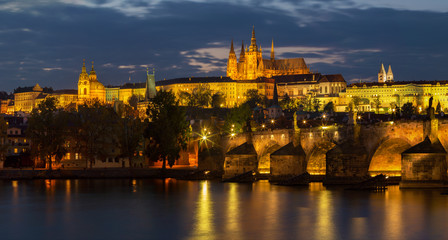 Fototapeta na wymiar Prague - The Charles Bridge, Castle and Cathedral from promenade over the Vltava river at dusk.
