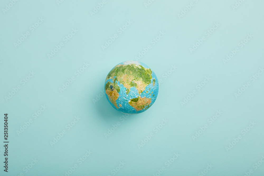 Wall mural top view of planet model on turquoise background, earth day concept