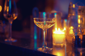 Vintage crystal glass on a blurred background. The atmosphere of a romantic dinner by candlelight.