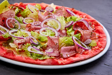 Homemade pizza with tomatoes, beef, pepper and red onion