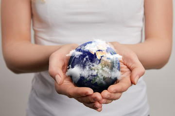 woman holding planet model on grey background, earth day concept