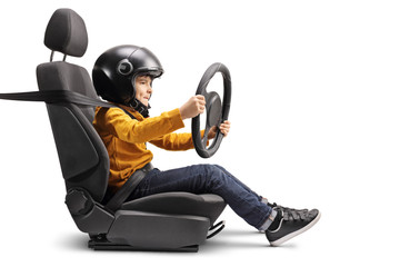 Little boy in a car seat with a helmet holding a steering wheel