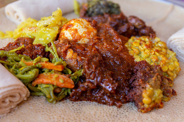 Injera with an assortment of toppings - obrazy, fototapety, plakaty