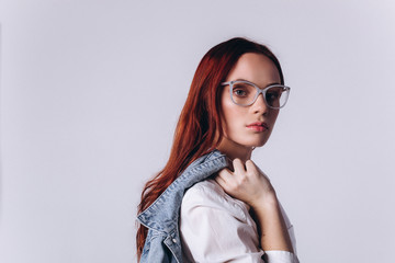 Portrait of young smart beautiful fashionable caucasian student girl with red headed hairstyle on white background. Business, knowledge, education concept