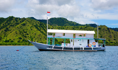Fototapeta na wymiar Komodo island, Indonesia, Indonesian boat off the coast of Komodo island. Traditional narrow Indonesian boats are equipped with hollow bamboo trunks on the sides for stability. On top of the deck is b