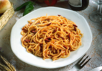 Un plato de espaguetis con salsa de tomate y guindillas.