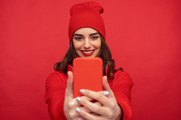 Stylish bright girl taking selfie with phone 