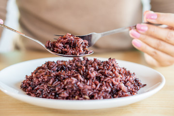 Asian woman hand eating healthy rice berry closeup 