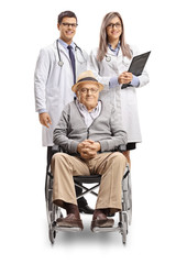 Fototapeta premium Disabled senior man in a wheelchair and a male and female doctor standing behind him