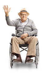 Disabled senior man in a wheelchair looking at the camera and waving