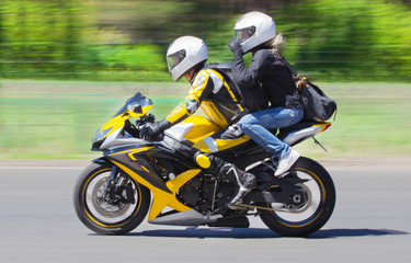 Active couple riding on the motorbike, slow motion, having fun in bikers tour, happy adventure concept on spring road