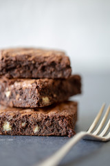 Chocolate brownies with fork close up pile of three