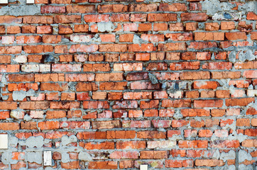 Background from old cracked red bricks with falling off tiles