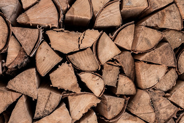 Birch firewood. Broken ax birch logs are in disarray.