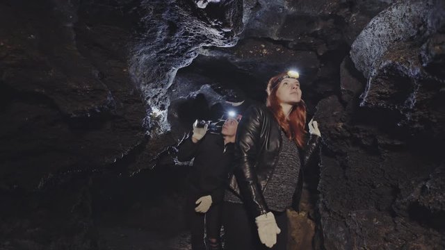 Group of speleologists walking through a rock cave