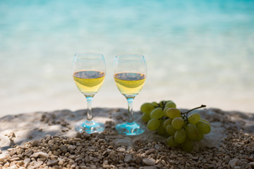 Two glasses of white wine with sea at background. Beach in Croatia