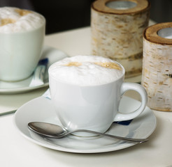 Cup of cappuccino reflecting in mirror