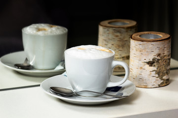 Cup of cappuccino reflecting in mirror