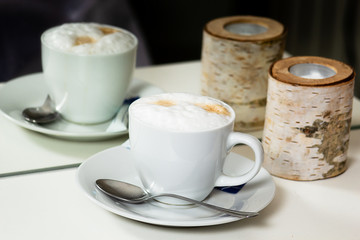 Cup of cappuccino reflecting in mirror