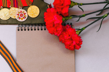 Only EDITORIAL. Moscow, RUSSIA, May 9, 2017: Red carnations and St. George ribbon on wooden background/St. George ribbon - the symbol of the great Victory/Victory Day