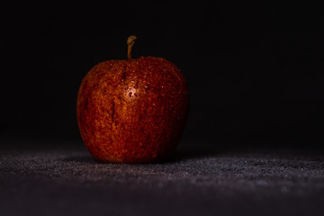 Red Apple on dark background with water drops