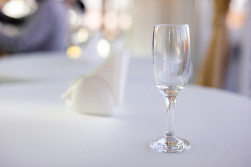 Natural light or daylight shot of modern restaurant table set for a lunch. Shallow focus on wine glass