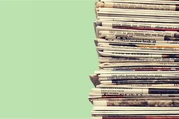 Pile of printed newspapers on blue background