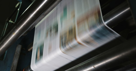 Print plant factory. Newspaper printing at a plant. Newspaper printed on a printing house machine....