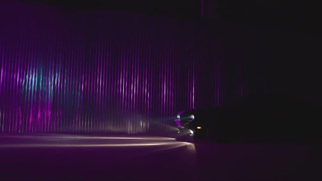 Silhouette of beautiful american muscle car on smoked dark background . Car lights on fog . 