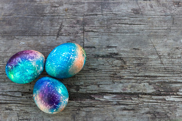 multicolored easter eggs space colors on wooden table