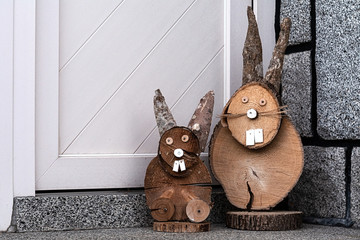 At the front door of the house there are two wooden rabbits.