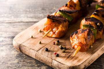 Chicken shish kebab with vegetables on wooden table