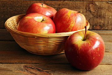 Basket of red apples on wood