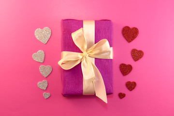 Present or gift box, paper heart and confetti on pink background top view. Valentines day greeting card. Flat lay style.