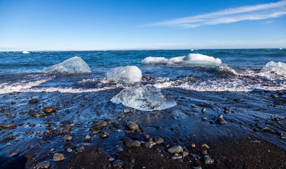panorama of icebergs floating on the black beach