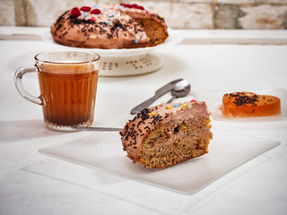 Sweet lunch with cake and fruit jelly on a white table, cutlery