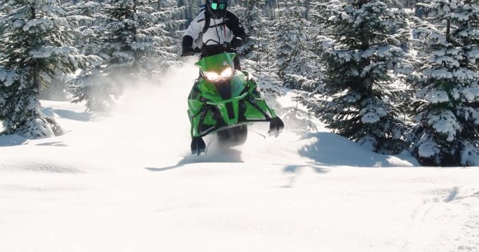 Extreme Winter Sports Athlete Riding Snowmobile at Camera in Sunlight