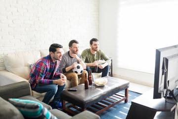 Friends Hanging Out In Living Room And Watching TV